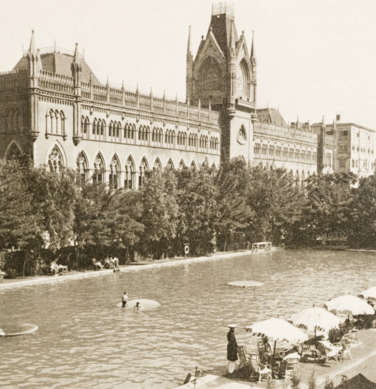 Calcutta Swimming Club, 1938. European bathers relax in and around the pool at Calcutta Swimming Club, in the shadow of the city's neo-Gothic High Court building. Calcutta (Kolkata), India, circa 1938. Kolkata, West Bengal, India, Southern Asia, Asia.