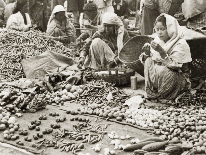 Fruit and vegetable stall at Darjeeling market. Two women sell various fruits, vegetables and spices, including chilli peppers and root ginger, on a stall at Darjeeling market. Darjeeling, India, 1942. Darjeeling, West Bengal, India, Southern Asia, Asia.