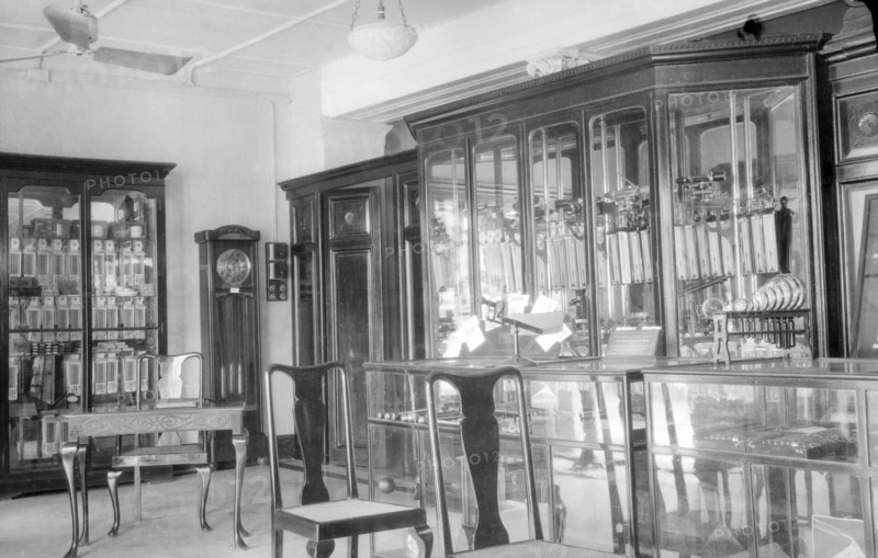 James Murray & Co.' showrooms, circa 1935. Interior of 'James Murray & Co.' on Old Court House Street, a British-owned family business that specialised in making chronometers and also operated as a jewellers and opticians. The showroom is filled with glass cabinets displaying watches and timepieces, with a grandfather clock standing in the corner. Calcutta (Kolkata), India, circa 1935. Kolkata, West Bengal, India, Southern Asia, Asia.