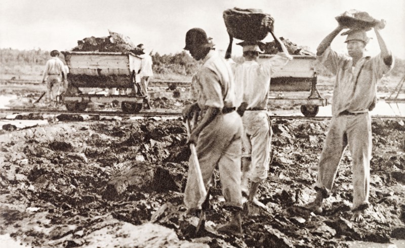 Extracting asphalt from the Pitch Lake. Labourers dig lumps of asphalt from the Pitch Lake and load it into a waiting rail car. Trinidad, circa 1938. La Brea, Trinidad and Tobago, Trinidad and Tobago, Caribbean, North America .