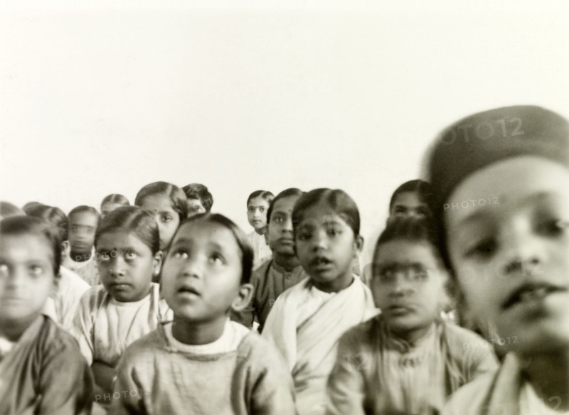 Indian schoolchildren. A class of Indian schoolchildren sit on the floor and listen attentively to an unseen speaker at a Methodist missionary school. Tumkur (Tumakuru), Karnataka, India, circa 1932., Karnataka, India, Southern Asia, Asia.