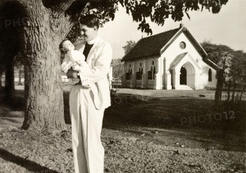 Methodist missionary cradling his daughter. Methodist missionary Reverend Norman Sargant cradles his baby daughter Nell outside Chikmagalur Church. Chikmagalur, Mysore State (Chikkamagaluru, Karnataka), India, February 1937., Karnataka, India, Southern Asia, Asia.