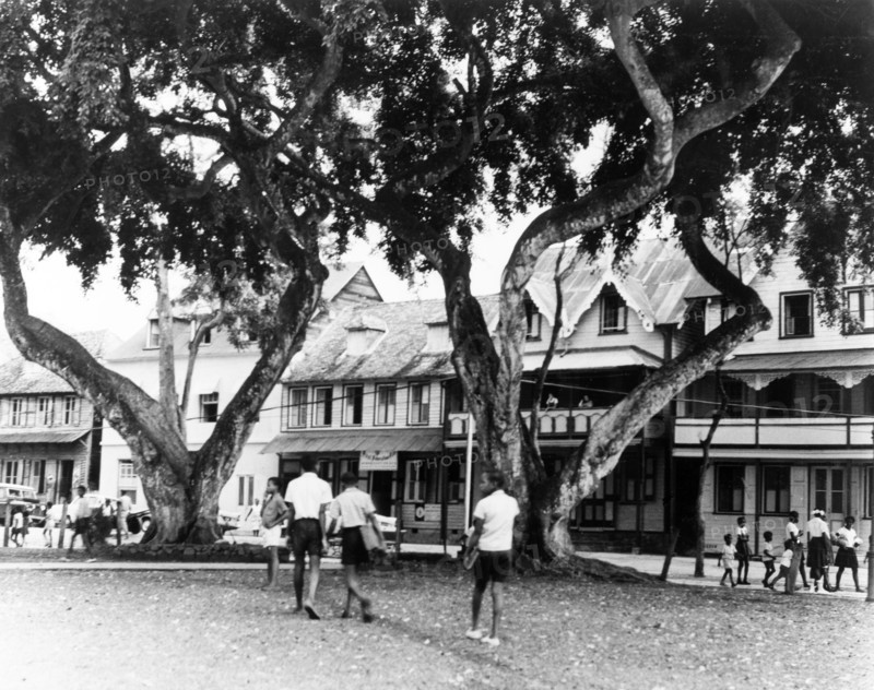 Town square in Old Castries. Schoolchildren cross a town square in Old Castries, lined with colonial-style buildings. Castries, St Lucia, 1965. Castries, St Lucia, St Lucia, Caribbean, North America .