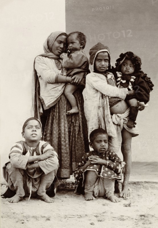 Child beggars, India. Portrait of a group of six children, including two infants, begging on the street outside the Empire Hotel. Agra, India, December 1902. Agra, Uttar Pradesh, India, Southern Asia, Asia.