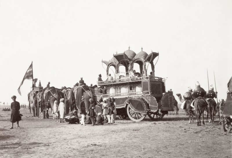 Alwar State procession at Coronation Durbar, 1903. A team of caparisoned elephants pull Alwar State's large, ceremonial carriage at the Coronation Durbar. The ornate vehicle has two storeys: the enclosed lower section for female passengers and the open upper level for men. Delhi, India, circa 1 January 1903. Delhi, Delhi, India, Southern Asia, Asia.