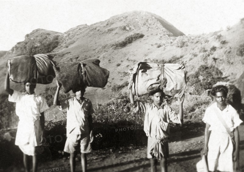 Indian porters in the Baba Budan Giri mountains. A team of Indian porters balance large bundles on their heads as they trek through the Baba Budan Giri mountain range. Mysore State (Karnataka), India, circa 1936., Karnataka, India, Southern Asia, Asia.