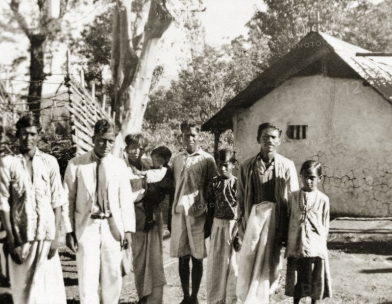 Evangelists visiting plantation workers, India. Two Methodist evangelists, J.A. Dennis and Monahan Peter (both standing far left), pose with plantation workers at the 'Maskal Maradi' coffee estate, whilst on a visit with British missionary Reverend Norman Sargant. Chikmagalur, Mysore State (Chikkamagaluru, Karnataka), India, circa 1936., Karnataka, India, Southern Asia, Asia.