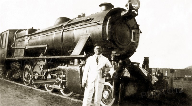 A narrow gauge steam train. Reverend Norman Sargant poses in front of a narrow gauge steam train as he prepares to travel from Mysore to Poona (Pune). Mysore, India, September 1938. Mysore, Karnataka, India, Southern Asia, Asia.