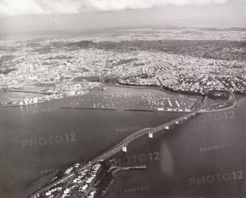 Aerial view of Auckland Harbour Bridge. Auckland Harbour Bridge stretches across Waitemata Harbour towards Auckland city. Auckland, New Zealand, 1966. Auckland, Auckland, New Zealand, New Zealand, Oceania.