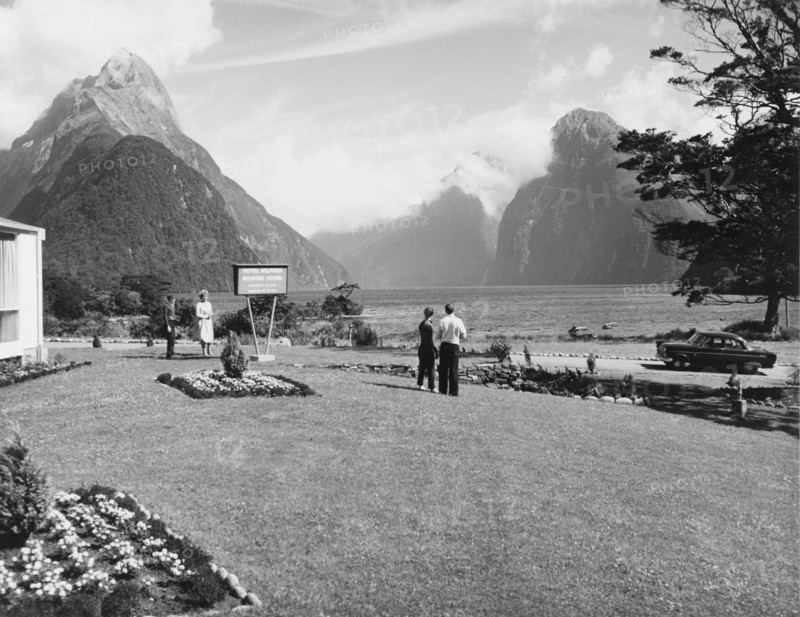 Milford Sound from the Milford Hotel. A couple admire the view of Milford Sound from the lawn of the Milford Hotel. Southland, New Zealand, 1966., Southland, New Zealand, New Zealand, Oceania.