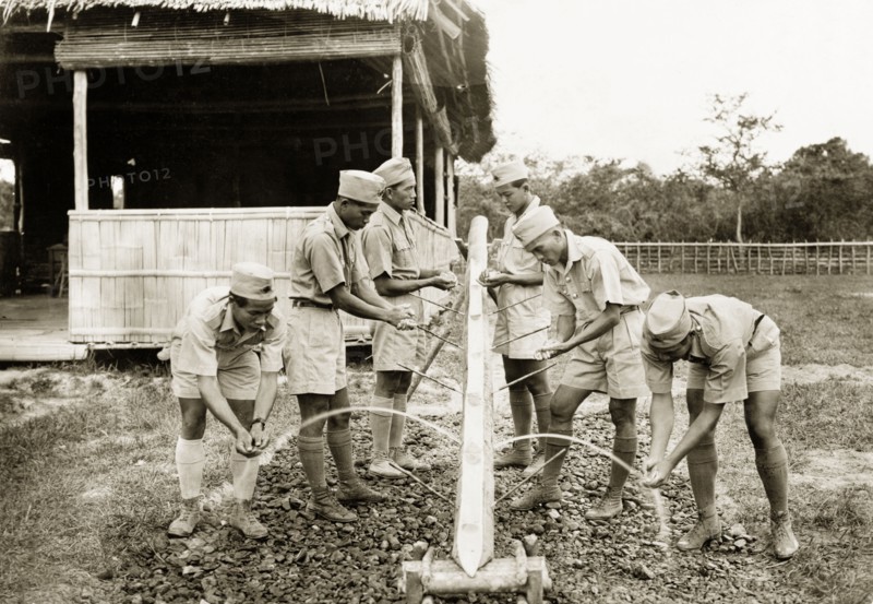Wash stand at Keningau Health Centre. Trainee health officers at Keningau Health Centre wash their hands at a wash stand fashioned from a length of bamboo. Health officers were trained by British medical officers at the centre to introduce new hygiene and sanitation practices to local villages. Keningau, North Borneo (Sabah, Malaysia), circa 1937. Keningau, Sabah (North Borneo), Malaysia, South East Asia, Asia.