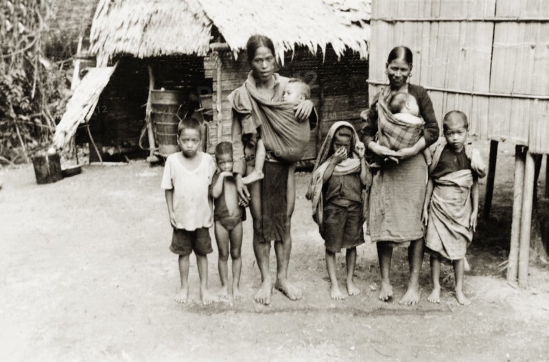 A large Malay family, North Borneo. Group portrait of a Malay family, two parents and six young children, standing barefoot outside a stilted building in a village near Keningau. Keningau, North Borneo (Sabah, Malaysia), circa 1937. Keningau, Sabah (North Borneo), Malaysia, South East Asia, Asia.