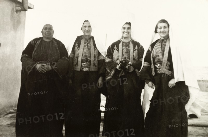 Women in traditional Palestinian attire. Group portrait of four women, dressed in traditional Palestinian 'thobs'. Related photographs show that the woman second from right had recently been married to Edward Keith-Roach, District Governor of Jerusalem, in a traditional Christian ceremony. Jerusalem, British Mandate of Palestine (Israel), circa 1939. Jerusalem, Jerusalem, Israel, Middle East, Asia.