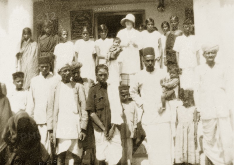 Staff at Mandagadde Hospital. A European doctor and Indian staff from the Mandagadde Methodist Mission Hospital pose for a group portrait with their families on the steps outside. Mandagadde, Mysore State (Karnataka), India, circa 1933., Karnataka, India, Southern Asia, Asia.