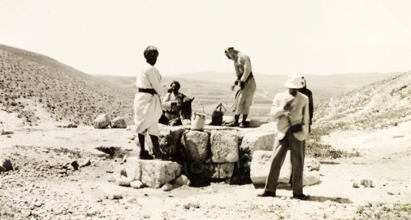 Drawing water from a desert well. A party of travellers draws water from a desert well in Al-Masfara, a mountainous region to the west of the Dead Sea. An original caption identifies one of the men as Dr. Krikorian, possibly Samuel Krikorian, an Armenian missionary of the Church of the Nazarene. British Mandate of Palestine (West Bank, Middle East), 2-9 April 1941., West Bank, West Bank (Palestine), Middle East, Asia.
