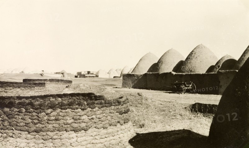Bedouin mud dwellings near Aleppo. A Bedouin village near Aleppo, containing a number of beehive-shaped adobe mud dwellings. Near Aleppo, French Mandate of Syria (Syria), 1941. Aleppo, Syria, Syria, Middle East, Asia.