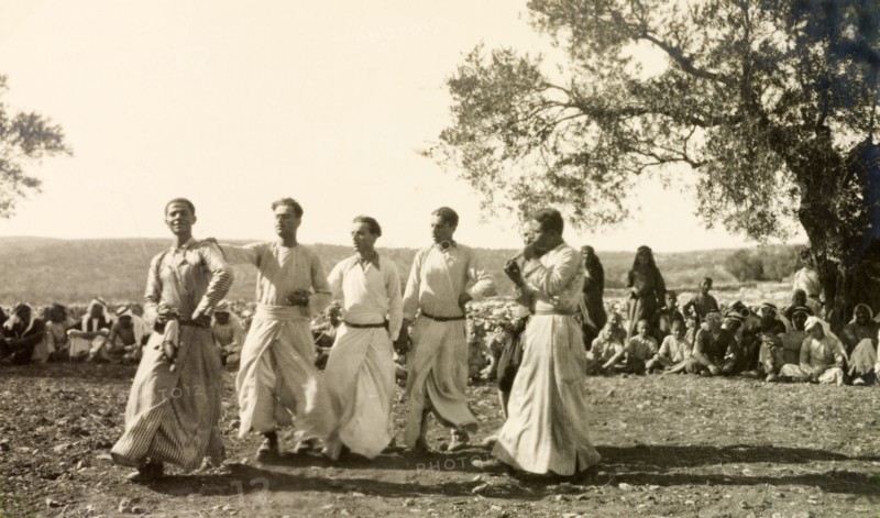Dabke' dance at a Palestinian wedding. A group of men dressed in 'thobs' (ankle-length garments with long sleeves) perform a traditional 'dabke' folk dance at a Palestinian wedding. Salfit, British Mandate of Palestine (West Bank, Middle East), 17 September 1941. Salfit, West Bank, West Bank (Palestine), Middle East, Asia.