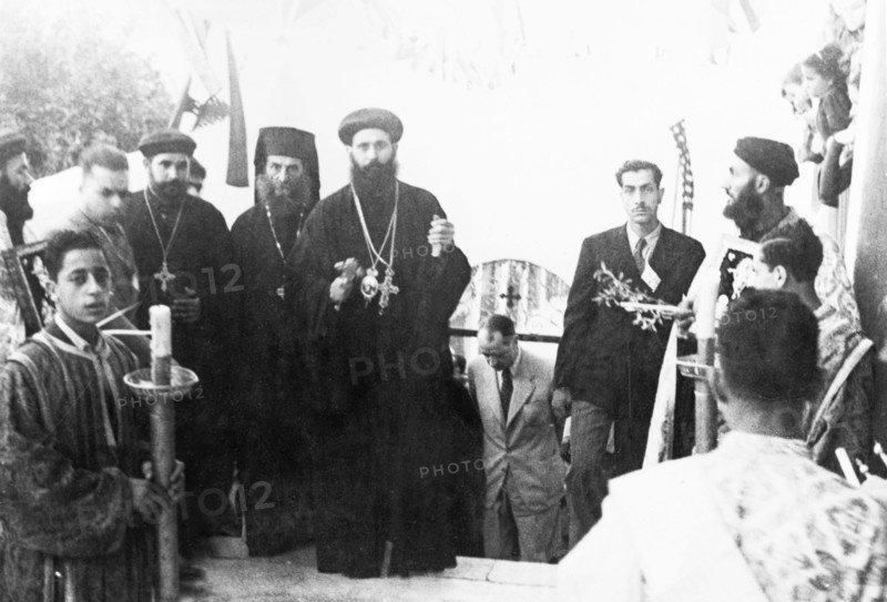 Priests at the Coptic Convent in Jaffa. Several Coptic priests take part in a ceremony at the Coptic Convent in Jaffa, wearing black floor-length robes and heavy, ornate crosses. Behind them, at the bottom of the steps, is William Ryder McGeagh, District Commissioner in Jerusalem. Jaffa, British Mandate of Palestine (Israel), April 1947. Jaffa, Tel Aviv, Israel, Middle East, Asia.
