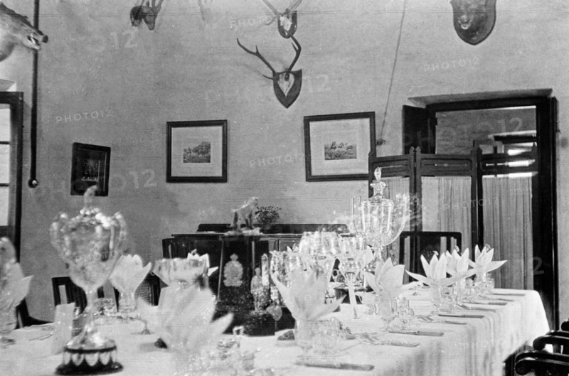 Dining room at the Police Training School. Various trophies form the centrepiece of a table that has been set for a formal dinner for the Inspector-General of Police, Harold Poe, at Moradabad's Police Training School. The wall behind is decorated with framed pictures and hunting trophies. Moradabad, United Provinces (Uttar Pradesh), India, circa 1933. Moradabad, Uttar Pradesh, India, Southern Asia, Asia.