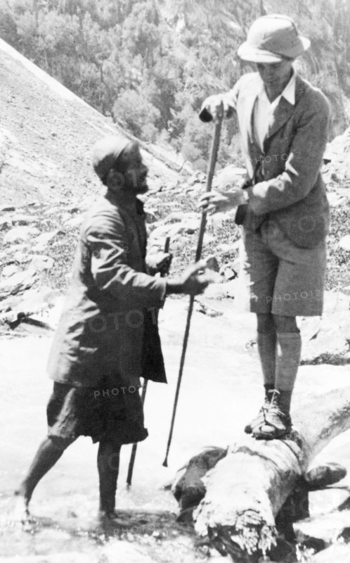 Preparing to cross a Kashmiri stream. George Boon balances precariously on a log as he prepares to cross a fast-flowing mountain stream near Sekwas Pass. Jammu and Kashmir, India, June 1934., Jammu and Kashmir, India, Southern Asia, Asia.