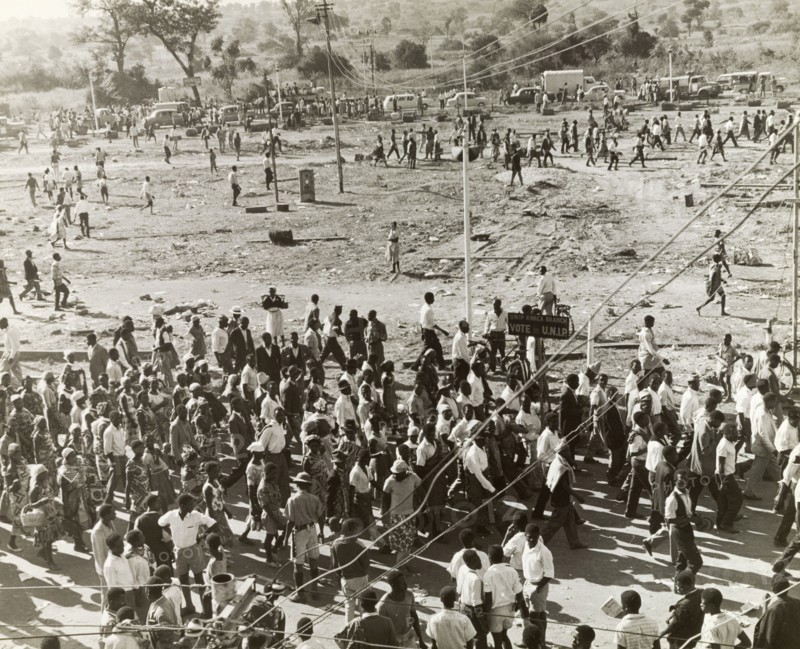 UNIP supporters at an electioneering rally. United National Independence Party (UNIP) supporters disperse following an electioneering rally held two months before Zambian independence. UNIP won the Zambian election of January 1964, but their authority was challenged by Alice Lenshina's Lumpa Church. Violent conflict ensued and in summer 1964, UNIP activists attacked the village of Peshuku, reportedly killing 46 people. Peshuku, Eastern Province, Northern Rhodesia (Zambia), August 1964. Peshuku, East (Zambia), Zambia, Southern Africa, Africa.