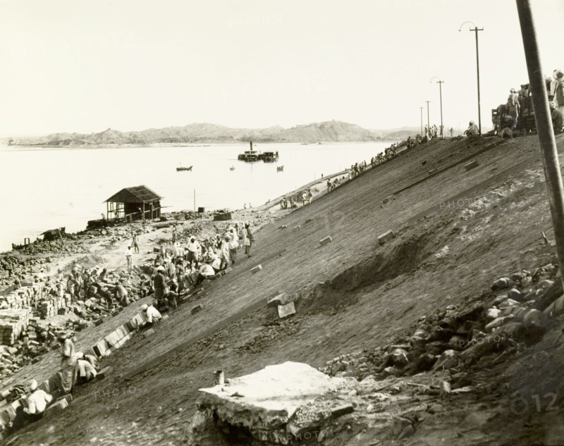 Constructing an embankment at Chauk. Labourers lay pitching bricks on a steep, clay-faced embankment beside the Ayeyarwady River. Related images suggest this may be the construction site of a new access road leading to the Chauk-Lanywa oilfield, raised high above the river to protect against annual flooding. Chauk, Burma (Myanmar), 1932. Chauk, Magway, Burma (Myanmar), South East Asia, Asia.