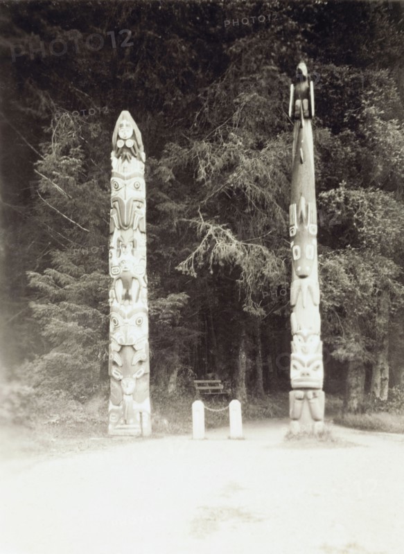 Totem poles in Sitka National Park. Two Native American totem poles mark the entrance to Lover's Lane in Sitka National Park. Sitka, Alaska, United States of America, circa 1931. Sitka, Alaska, United States of America, North America, North America .