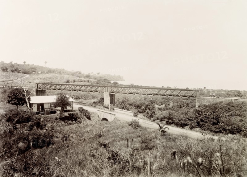 Railway bridge at Pointe-a-Pierre, Trinidad. A bridge carries a Trinidad Government Railways extension line across an incline at Pointe-a-Pierre. Pointe-a-Pierre, Trinidad, circa 1912. Point-a-Pierre, Trinidad and Tobago, Trinidad and Tobago, Caribbean, North America .