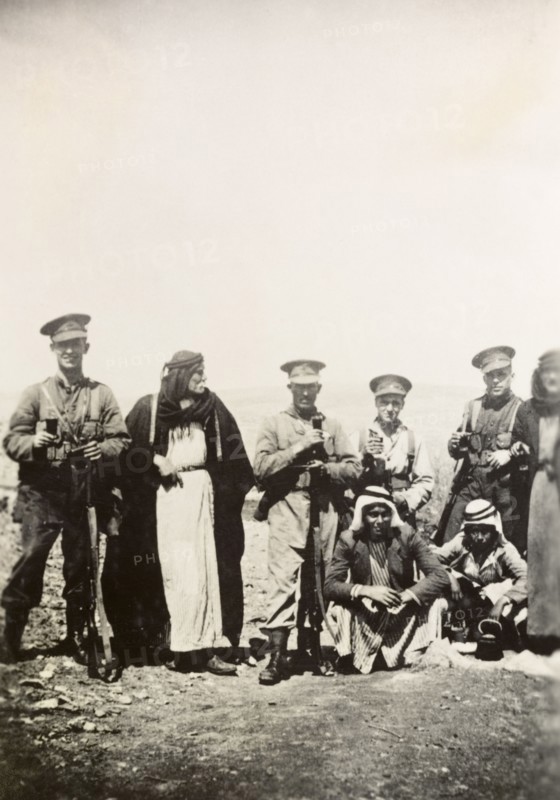 Royal Ulster Rifles with Arab villagers. Soldiers of the Royal Ulster Rifles, an Irish infantry regiment of the British Army, pose for a group portrait with four Arab villagers as they share a drink. During the period of the Great Uprising (1936-39), an additional 20,000 British troops were deployed to Palestine in an attempt to clamp down on Arab dissidence. British Mandate of Palestine (Middle East), circa 1938., Middle East, Asia.