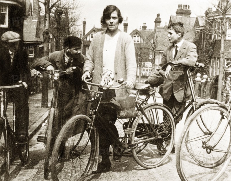 Cycling in Eastbourne. Enid Murray and several young men lean on their bicycles on a suburban street in Eastbourne. Eastbourne, England, 1922. Eastbourne, Sussex, England (United Kingdom), Western Europe, Europe .