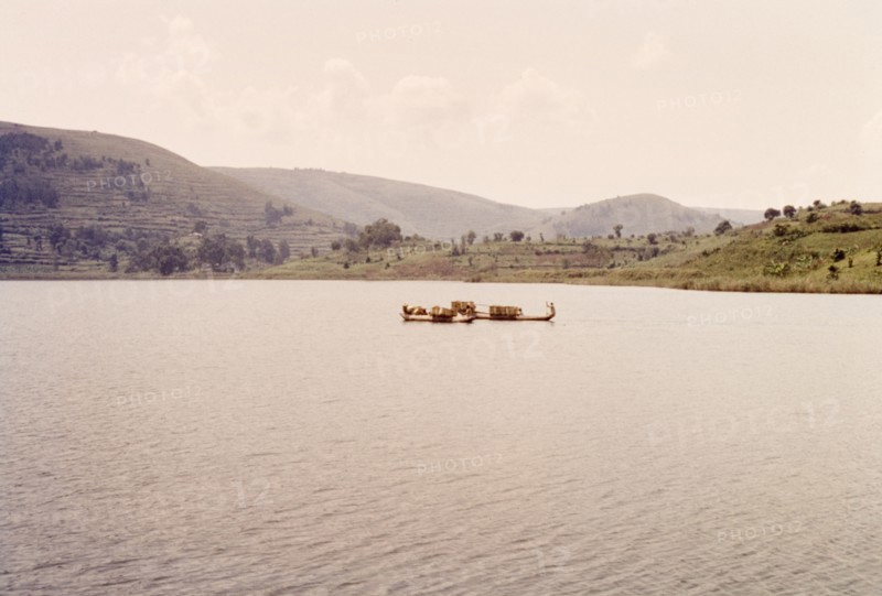 Dugout canoes on Lake Bunyonyi. Two dugout canoes filled with bamboo baskets float on the calm waters of Lake Bunyonyi near the Uganda-Rwanda border. Kigezi, South West Uganda, September 1963., West (Uganda), Uganda, Eastern Africa, Africa.