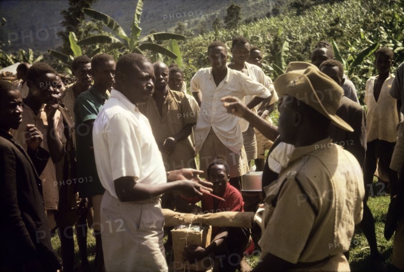 Recruiting porters at Budadiri. A Ugandan Forest Ranger negotiates for porters with a chief at Budadiri, one of the highest villages on the slopes of Mount Elgon. The expedition was organised to erect an aluminium rondavel on the mountain for use by the Uganda Mountain Club. East Uganda, 1962., East (Uganda), Uganda, Eastern Africa, Africa.
