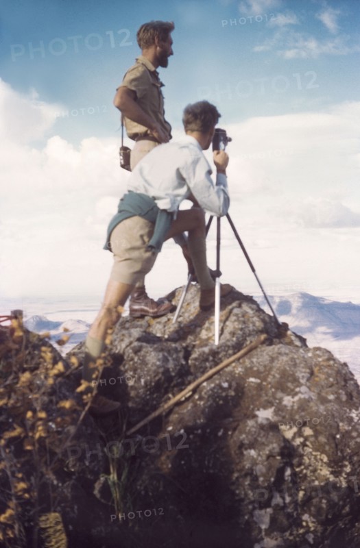 On the summit of Mount Napak. District Forestry Officer James Lang Brown (left) surveys Karamoja from the summit of Mount Napak. With him, crouched behind a camera and tripod, is Assistant District Commisioner John Cleeve. North East Uganda, December 1958., East (Uganda), Uganda, Eastern Africa, Africa.