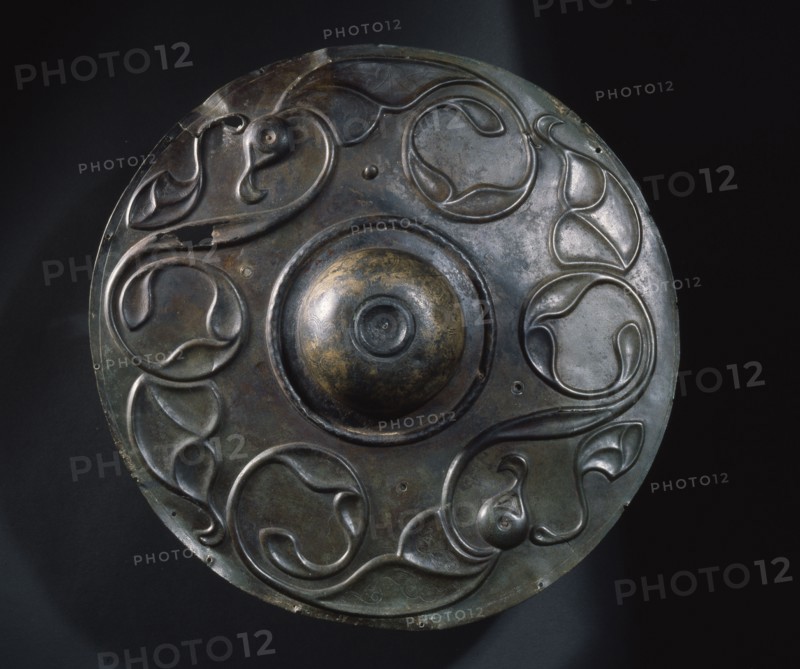 Decorated in a combination of repousse and incision style with two large birds whose wings develop into tendril motifs, this bronze boss is all that remains of a Celtic shield which was found in the Thames at Wandsworth, probably thrown there as an offering to the gods