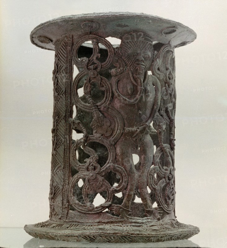 A stand that incorporates the image of a warrior with face scarifications