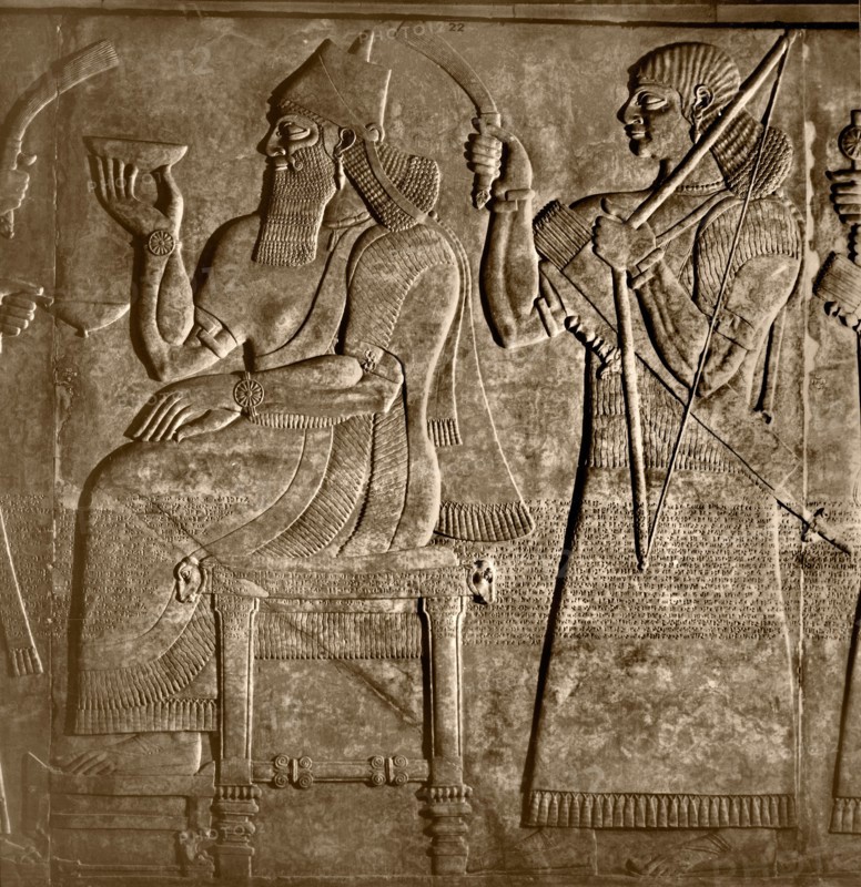 The king, Ashurnasirpal is seated between two attendants