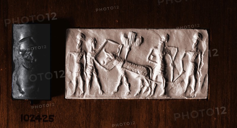 Cylinder seal of a man holding an ox which pulls a seed plough guided by two further bearded figures