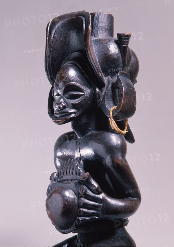 Chief holding a sanza, a musical instrument of the ideophone family, with metal keys and gourd resonator