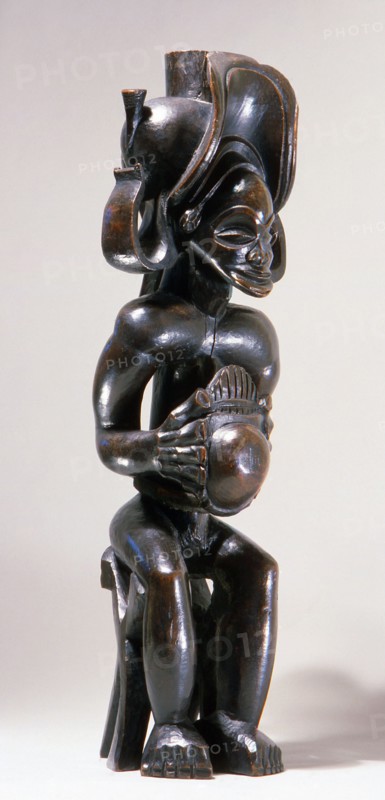 Chief holding a sanza, a musical instrument of the ideophone family, with metal keys and gourd resonator