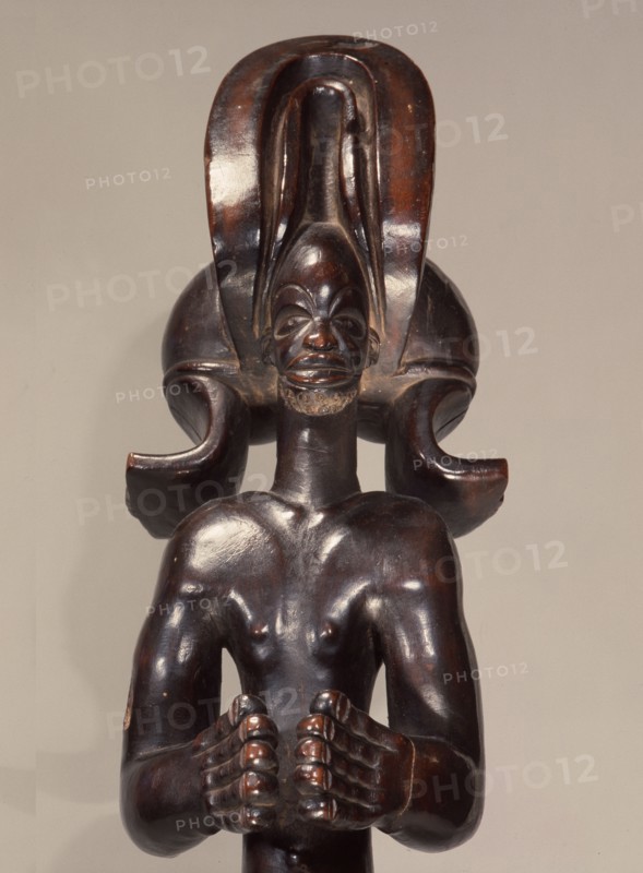 Wood figure wearing headdress that is characteristic of Chokwe chiefs and also found on important masks