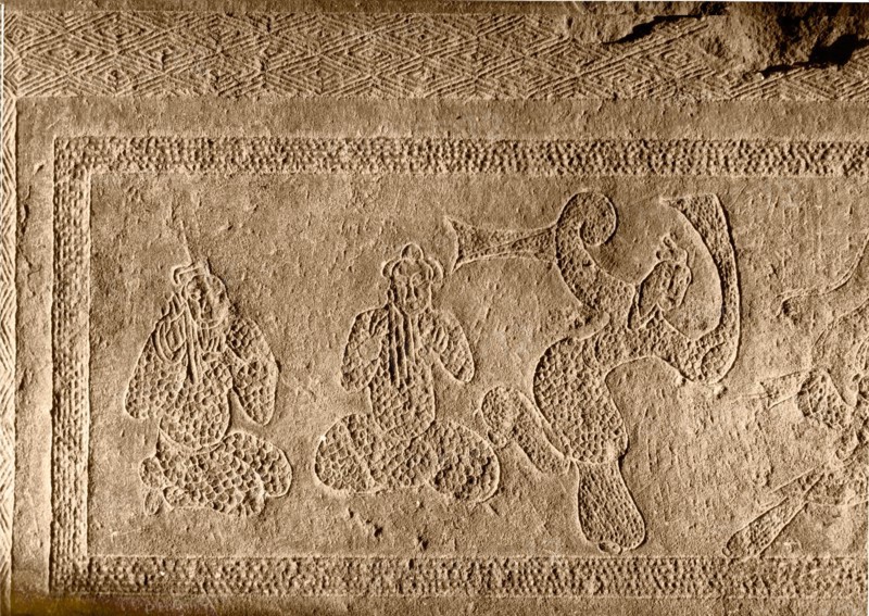 Brick from a tomb structure impressed with a desing depicting players of pan pipes and a dancer