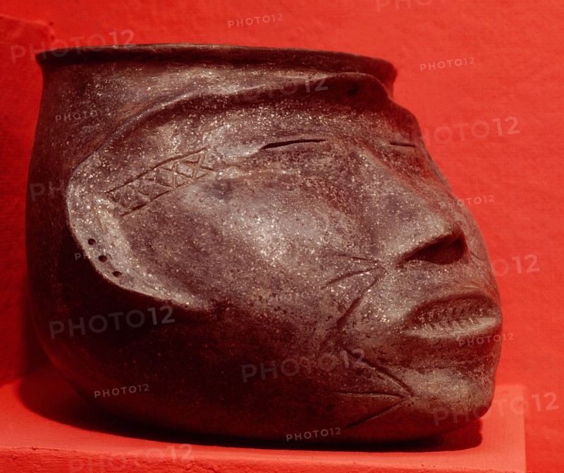 Pottery effigy head vessel representing a trophy head with sealed eyes and mouth sewed shut