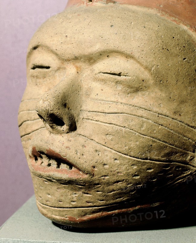 Pottery effigy head vessel with sealed eyelids, stitched mouth and facial decorations