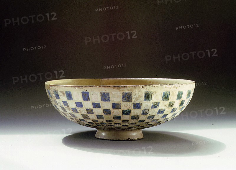 A pottery bowl with a blue and white chequer pattern on the outside