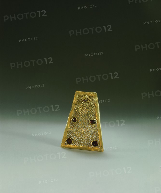 A gold & garnet fragment which would have been fastened with others to a necklace of cloth or leather