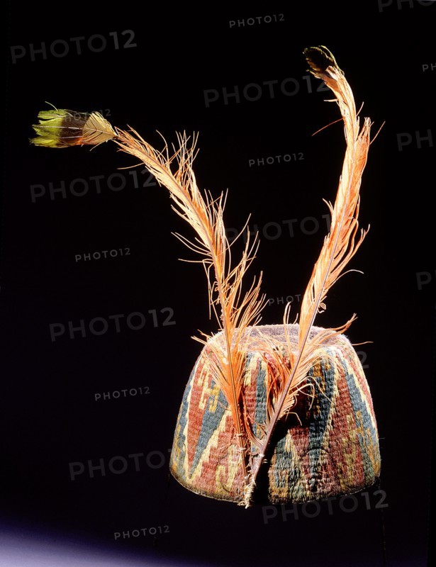 Fez style hat of coloured and twisted llama threads looped into coils, with triangular and step volute design
