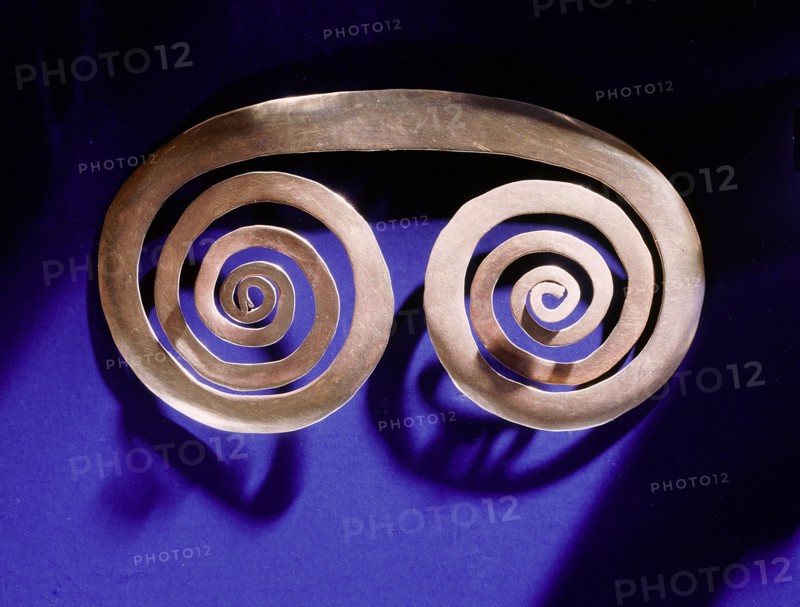 Gold spiral breast ornament thought to be a schematic representation of an owls face