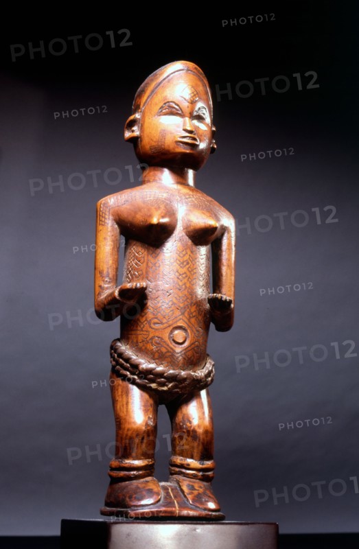Small wood figure with inset ivory eyes, showing female scarification patterns