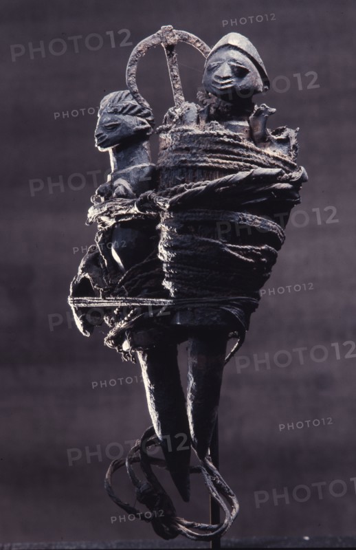 Iron, the symbol of Gu vodu of war, is bound in with two figures in this powerful Fon bocio medicine