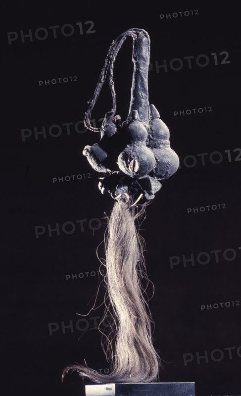 A magically charged fly whisk, with calabashes of powerful medicine on the handle